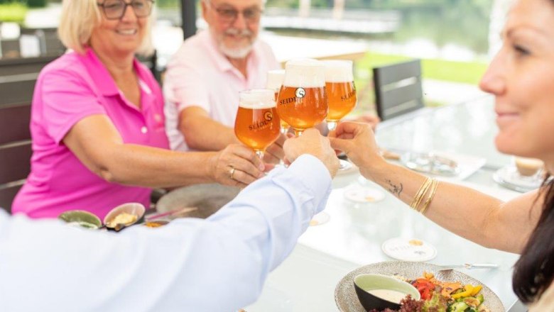 Gruppe stößt mit Biergläsern an, im Freien an einem Tisch., © Hotel-Restaurant Hausschachen