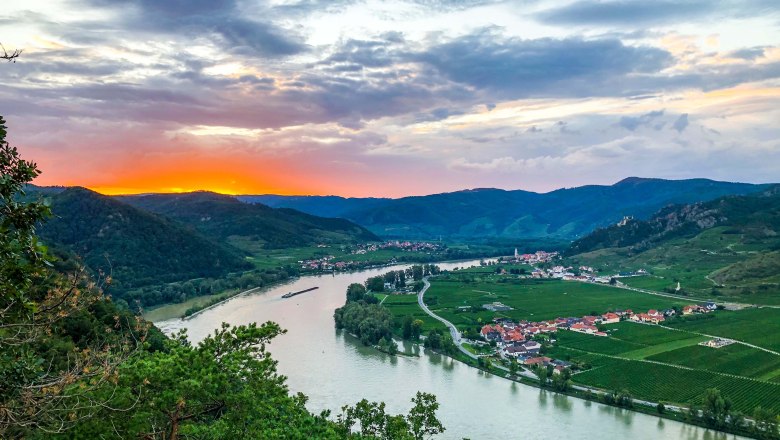 Sonnenuntergang über Flusslandschaft mit Hügeln und Dorf im Tal., © Donau Niederösterreich / Julia Schild