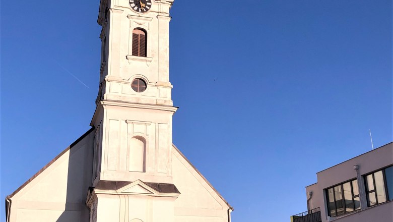 Kirchturm mit Uhr und Kreuz, daneben modernes Gebäude, blauer Himmel., © Donau NÖ Tourismus GmbH