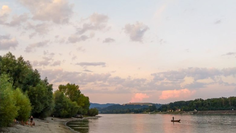 Sandstrand am Flussufer mit Bäumen und Boot bei Sonnenuntergang., © Donau NÖ Tourismus