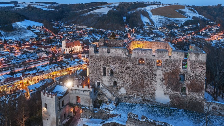 Burgruine Kirchschlag bei Nacht mit Ort im Hintergrund, © Wiener Alpen, Foto: Walter Strobl